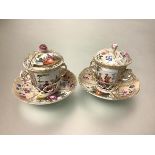 A pair of Berlin porcelain chocolate cups and covers on trembleuse saucers (one a/f), 19th