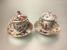 A pair of Berlin porcelain chocolate cups and covers on trembleuse saucers (one a/f), 19th