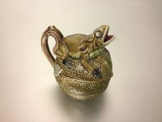 A Continental majolica jug, modelled as a frog crouching on a melon, painted mark to the base.