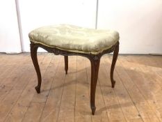 A late 19th century French walnut and parcel-gilt stool, the upholstered seat of serpentine outline,