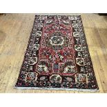 A Bakhtiari hand-knotted wool small carpet, the raspberry-sorbet field with central medallion