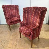 A pair of modern wing armchairs by Beaumont and Fletcher, each with barrel-shaped back, above a