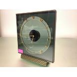 A 1950's mystery clock, with Swiss 17 jewel movement, the square smoked glass case within a