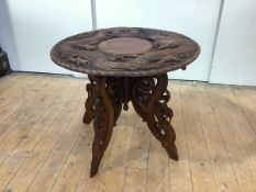 An early 20th century carved hardwood table, the circular top carved with a dragon within a bamboo