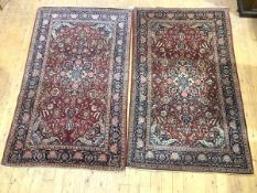 A pair of Kashan rugs, each madder field with central indigo medallion and corresponding