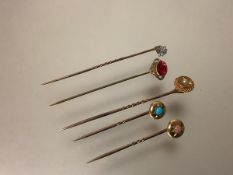 A group of five stick pins, early 20th century, one set with a seed pearl, the pin stamped "10", the