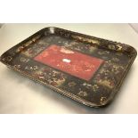 A large 19th century papier mache tray, rectangular, decorated in red and gilt against a black