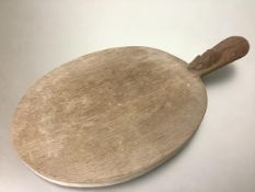 Workshop of Robert (Mouseman) Thompson, an oval oak cheese or bread board, with carved mouse