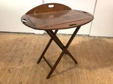 A 19th century oak butler's tray of characteristic form with pierced handles, on a folding stand.