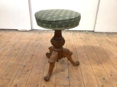A mid-19th century carved walnut adjustable piano stool, with revolving seat, on bulbous shaft, with