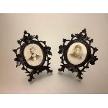 A pair of 19th century carved wooden photograph frames of Black Forest type, each oval aperture