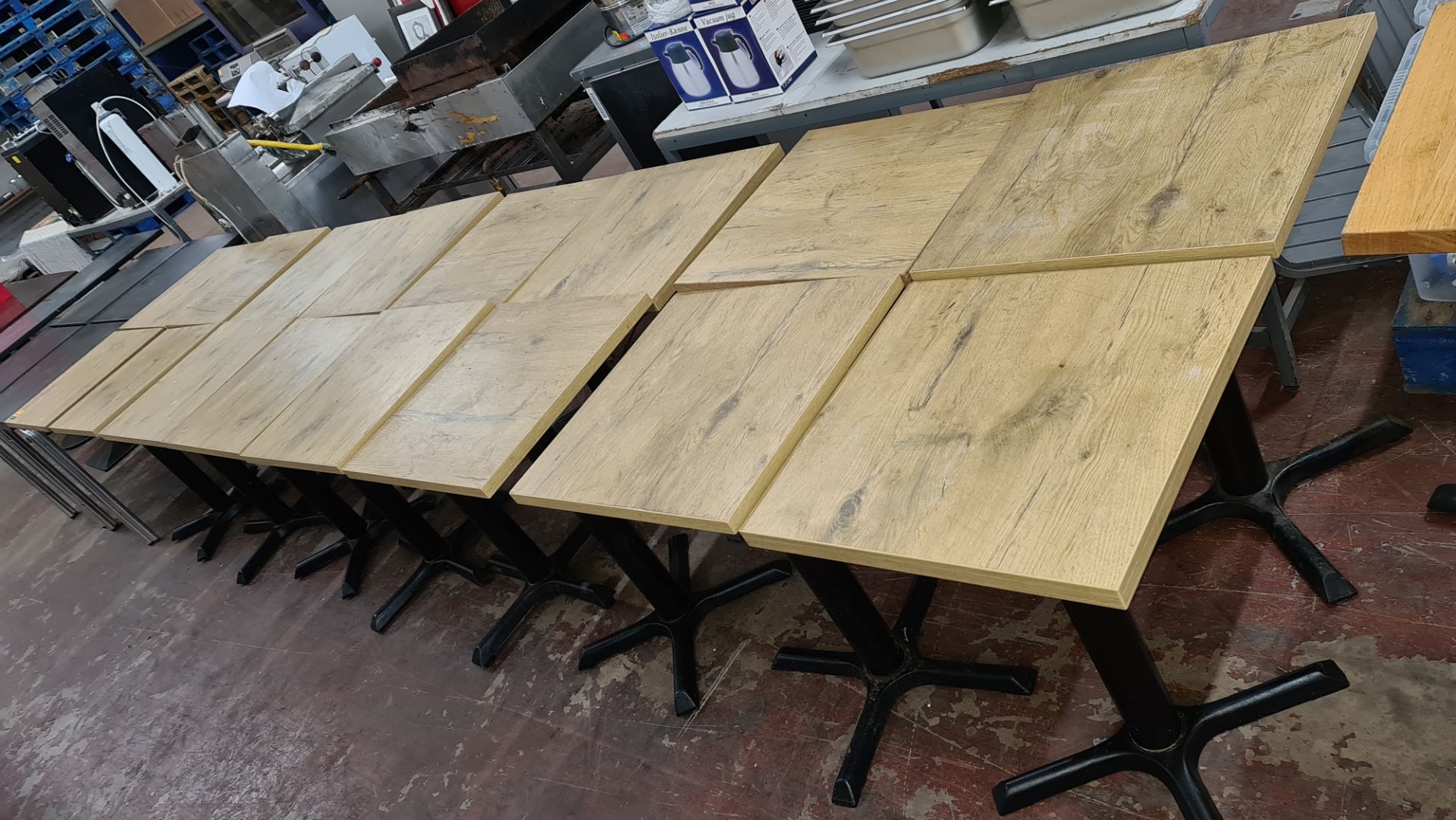 16 off matching café tables with black metal single pedestal bases & wooden tops each 500mm square