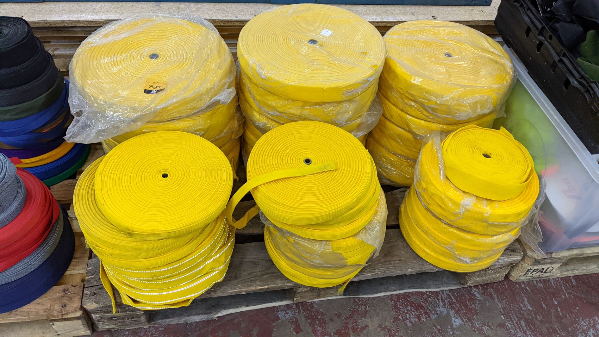 Quantity of reels of what is assumed to be belt fabric, in yellow, in 6 stacks