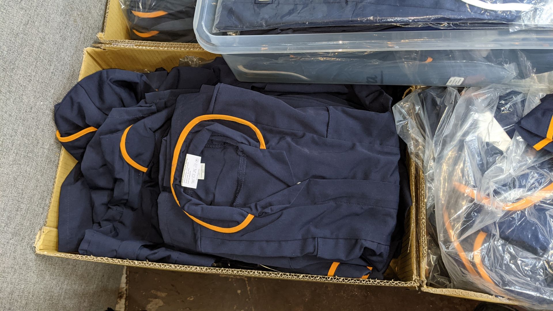 The contents of a pallet of short sleeve zip up navy tops with white or orange collars - this lot co - Image 4 of 6