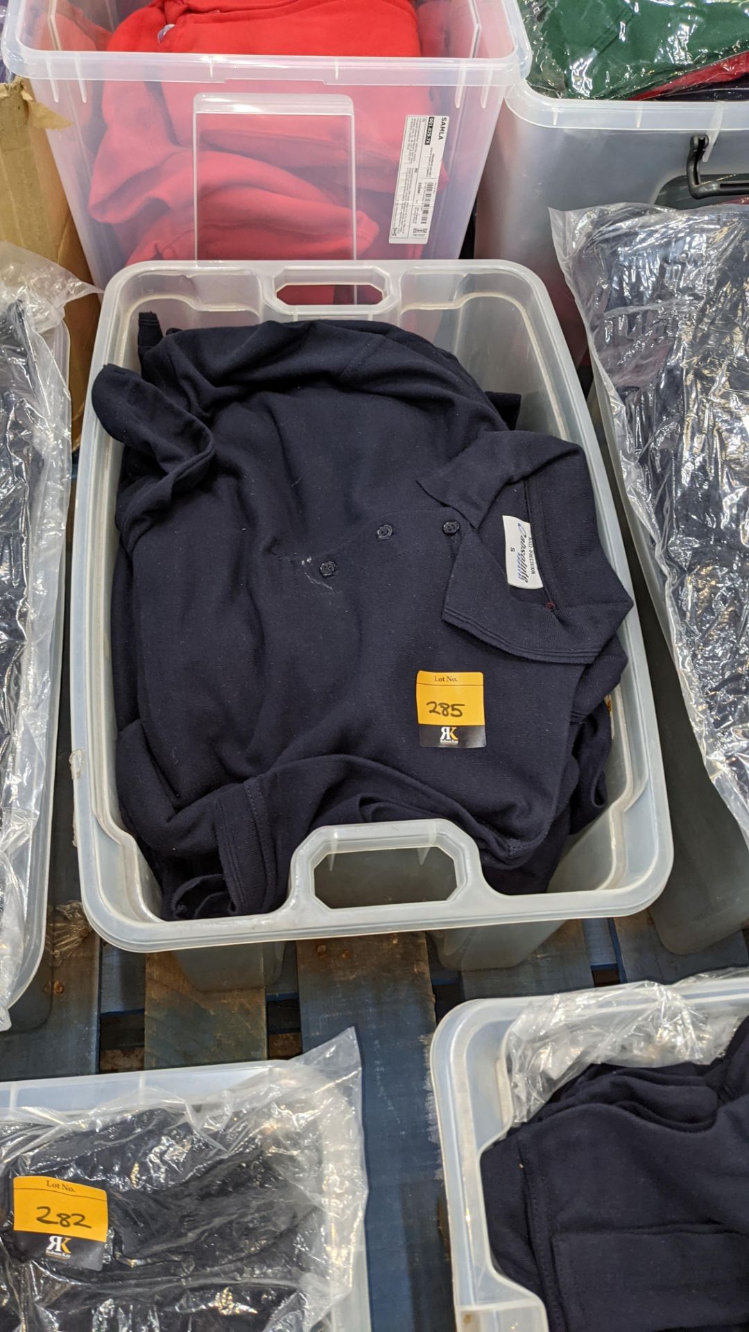 The contents of a crate of navy polo shirts. NB crate excluded