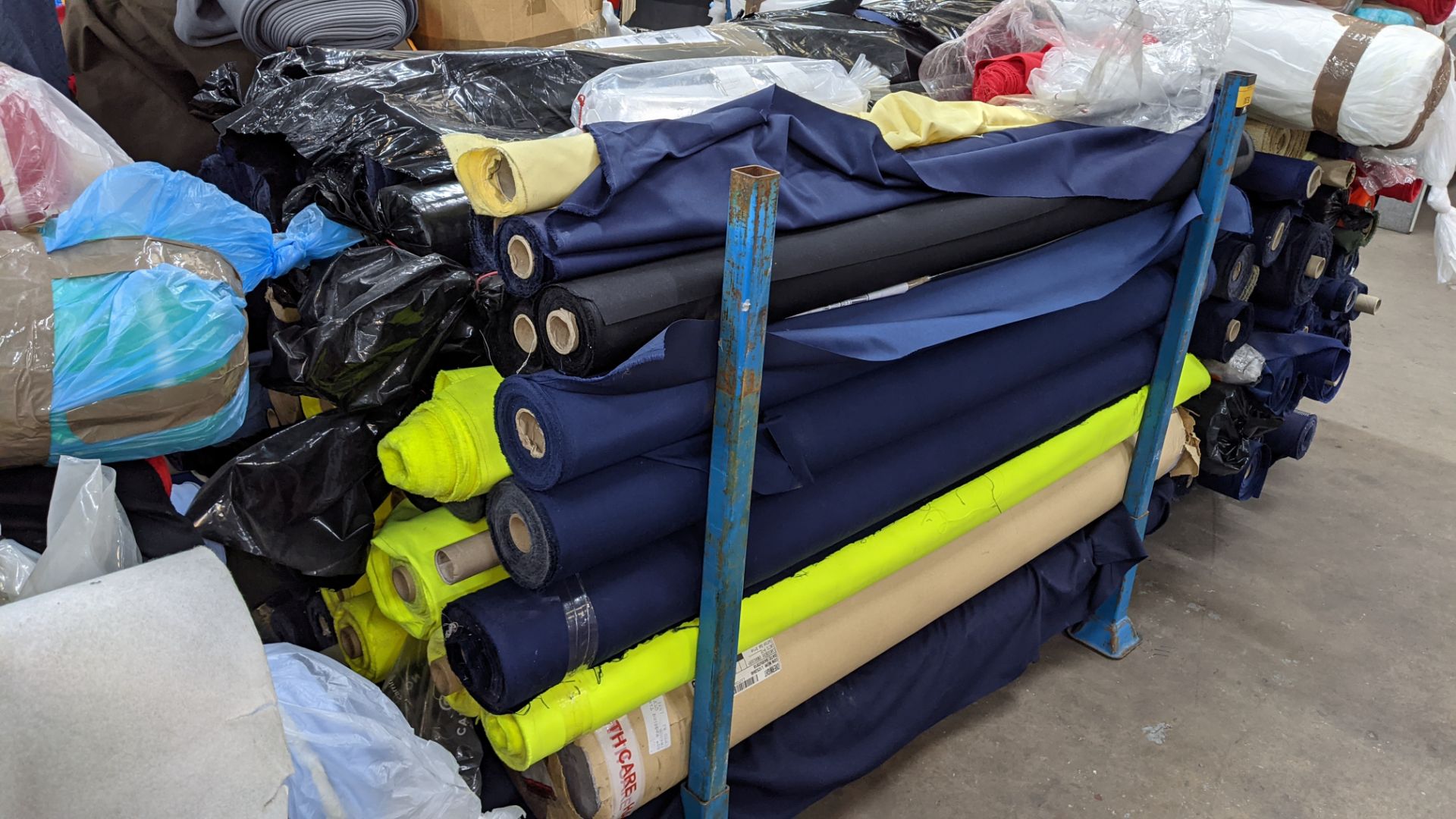 The contents of a large stillage of fabric including quantity of high visibility cloth. Please note