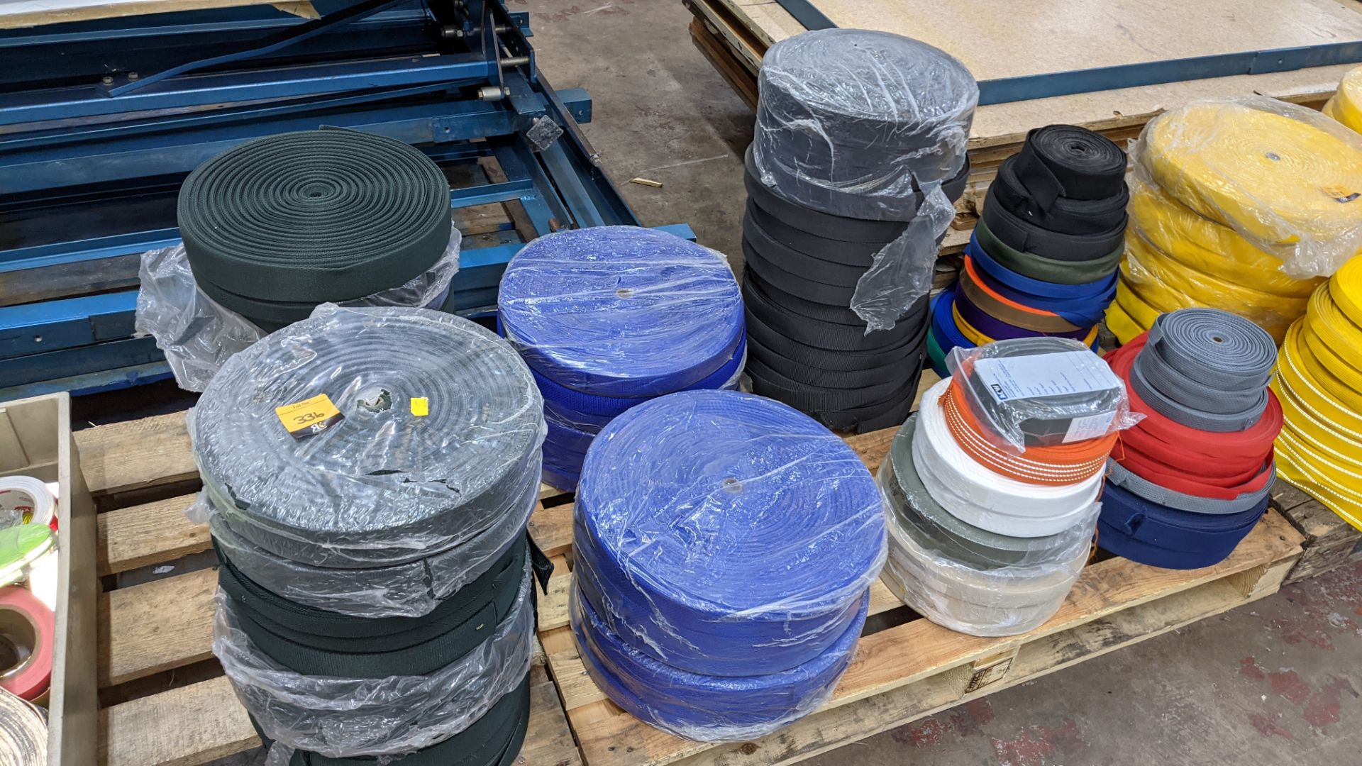 Quantity of reels of what is assumed to be belt fabric, in a variety of colours, in 8 stacks