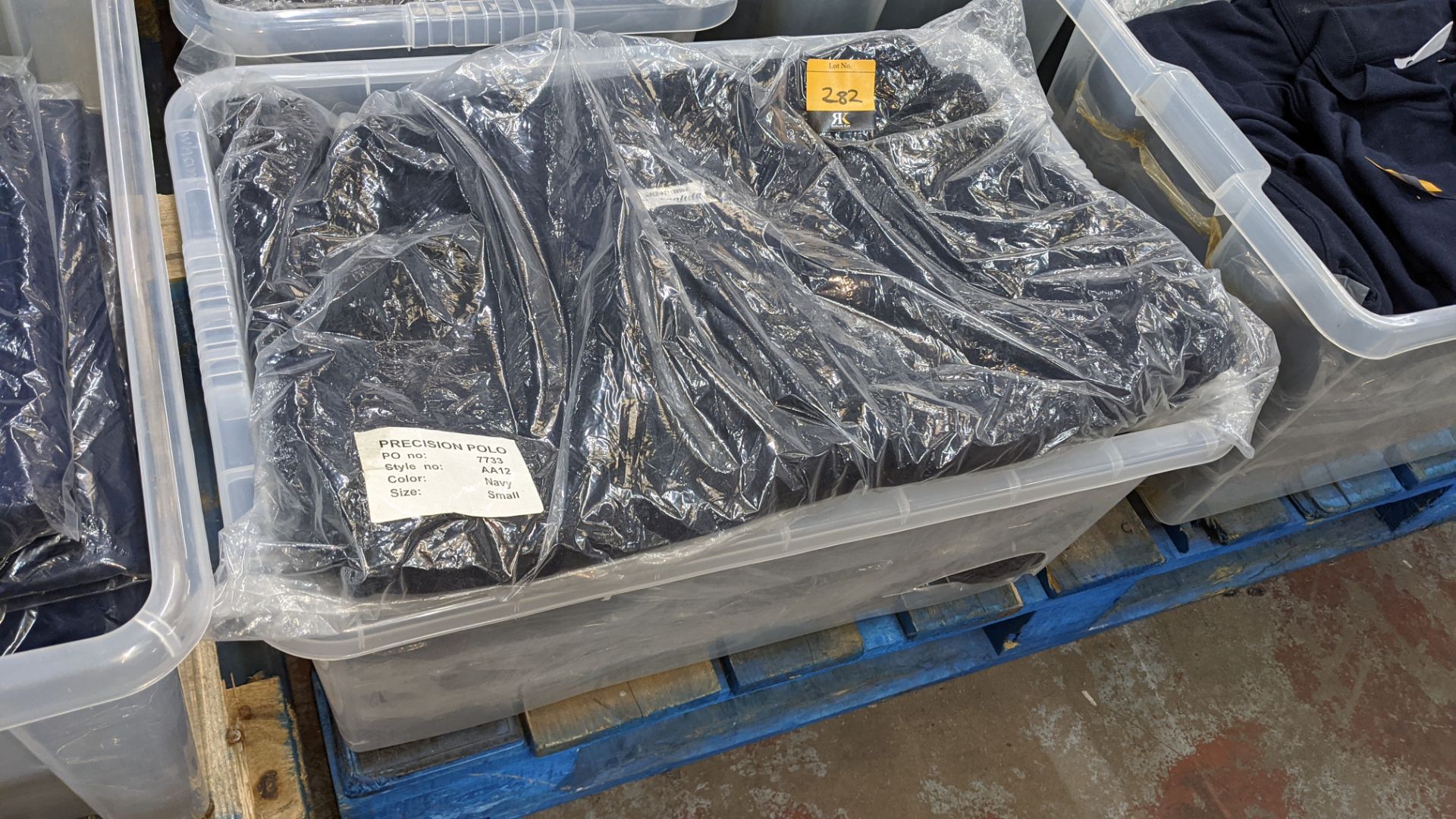 The contents of a crate of navy polo shirts. NB crate excluded