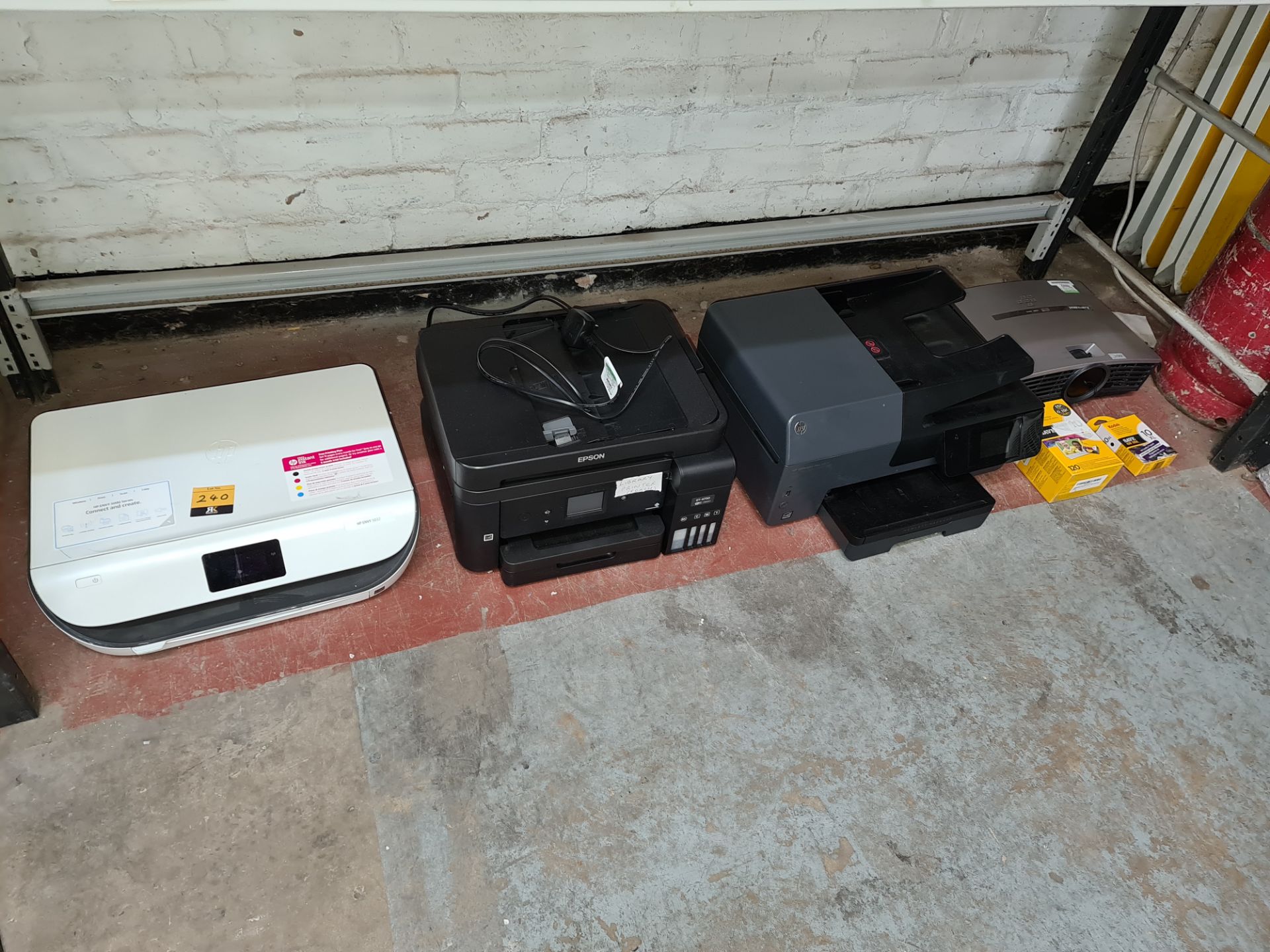 Contents of a bay of printers, plus projector and Kodak ink cartridges