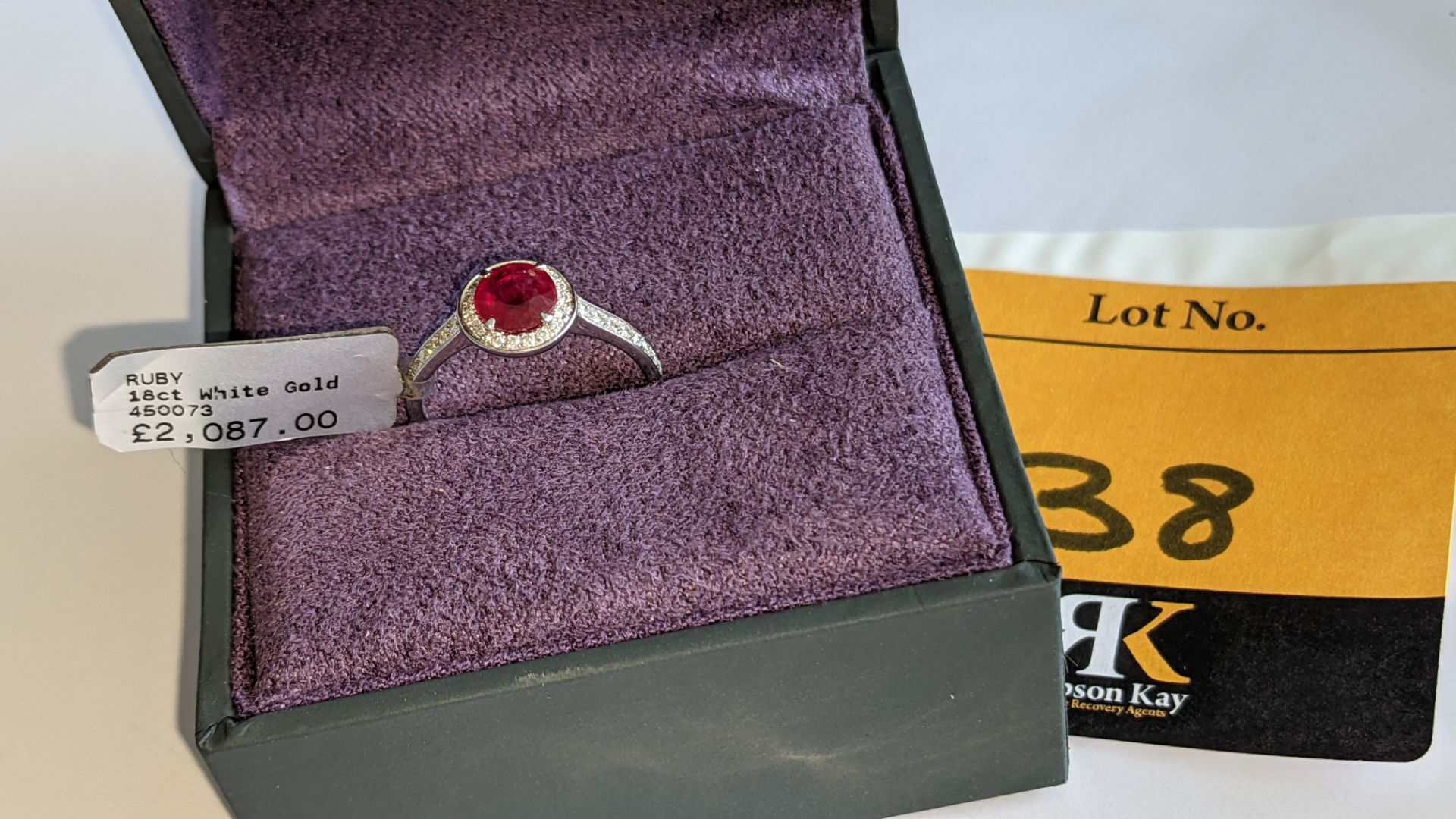 18ct white gold ring with central ruby & 0.27ct diamonds around the ruby & on each shoulder. RRP £2