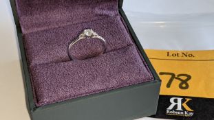 Platinum & diamond ring with a central stone flanked on the shoulders by smaller stones on either si
