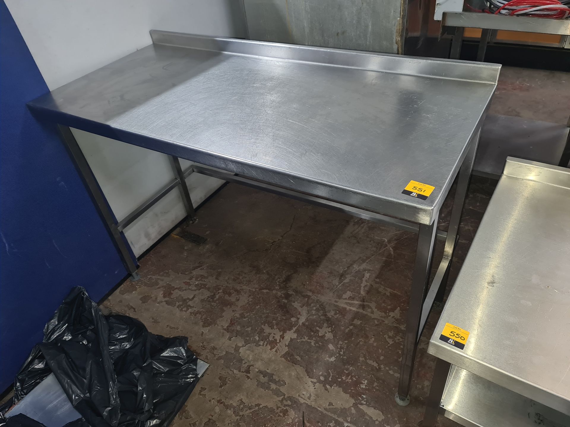 Stainless steel tall table with splashback measuring approx. 1300mm x 595mm