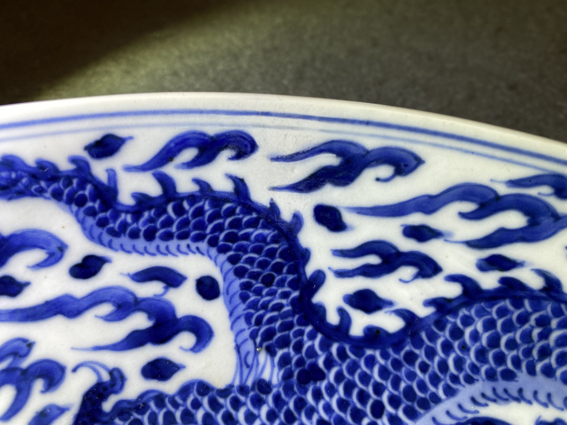 A Chinese blue and white 'dragon' dish, Kangxi mark and of the period - Image 3 of 12