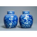 A pair of Chinese polychrome 'prunus on cracked ice' jars and covers, 19th C.