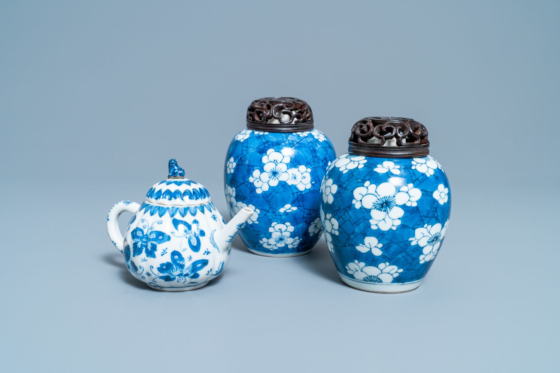 A pair of Chinese blue & white 'prunus' jars & a 'butterfly' teapot & cover, Kangxi