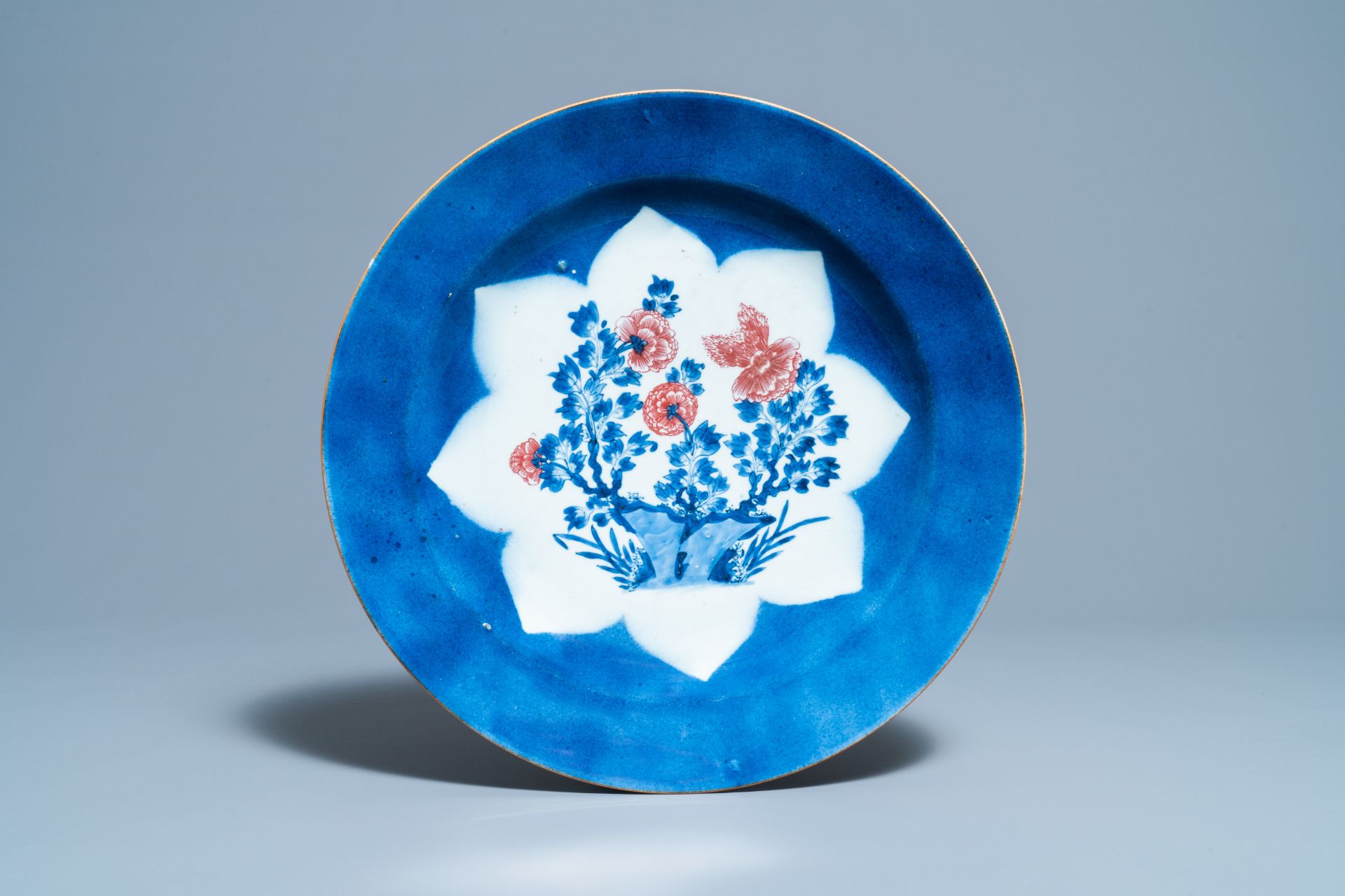 A Chinese blue, white and copper red powder blue-ground charger, Kangxi