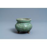 A Chinese monochrome celadon and crackle-glazed tripod censer, Ming