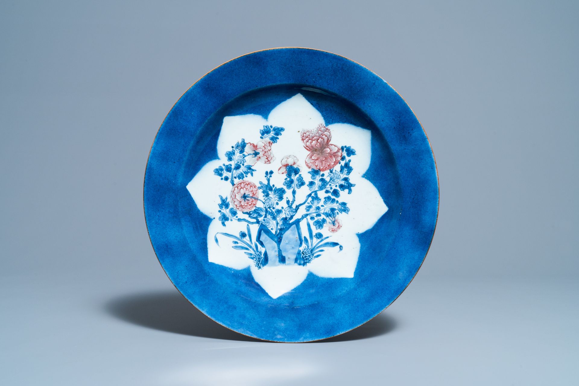 A Chinese blue, white and copper red powder blue-ground charger, Kangxi