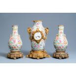 A Chinese gilt bronze-mounted three-piece Canton famille rose clock garniture, 19th C.