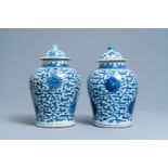 A pair of Chinese blue and white 'lotus scroll' vases and covers, Kangxi