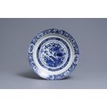 A Dutch Delft blue and white dish with a peacock in a Chinese garden, dated 1693