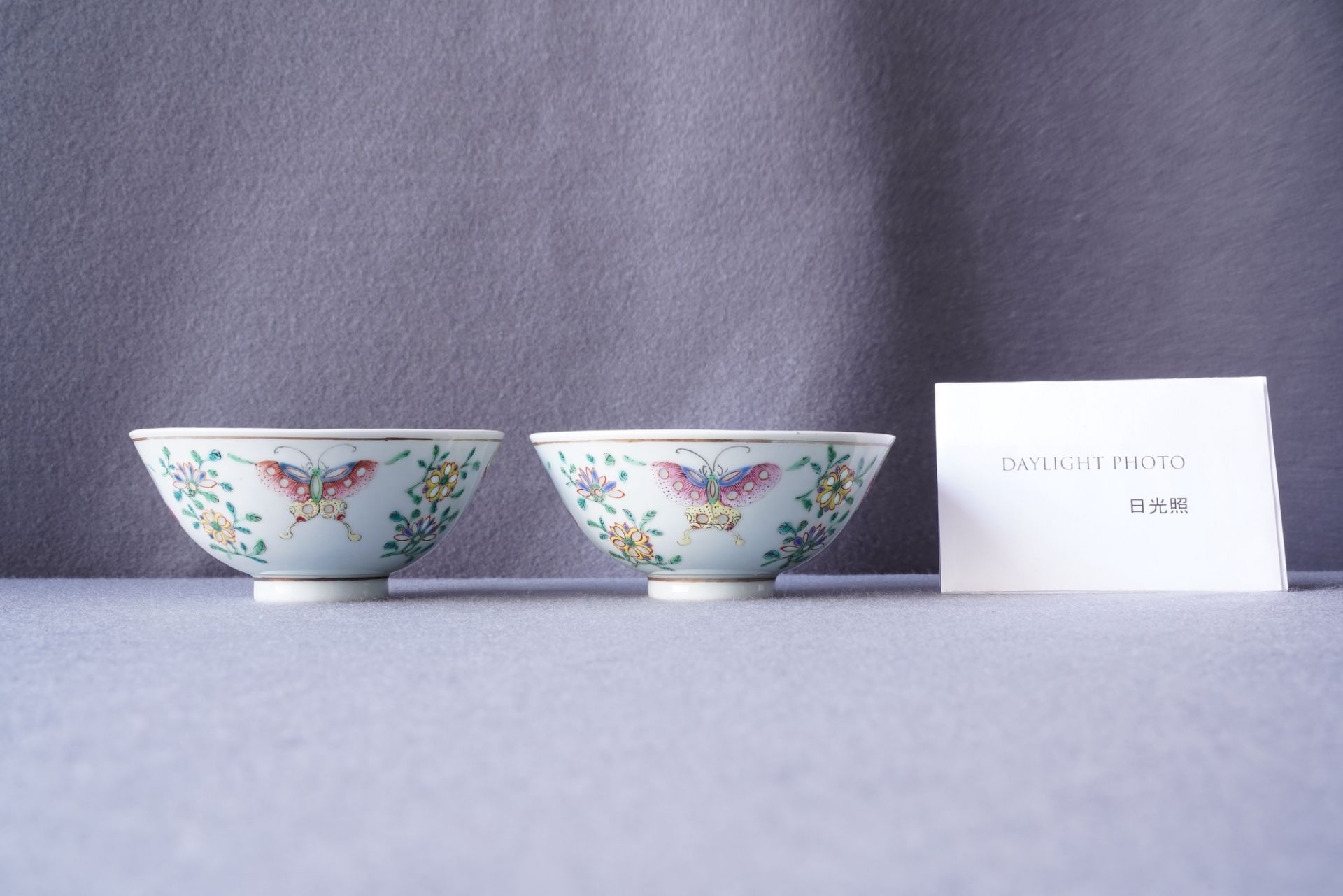 A pair of Chinese famille rose rice grain pattern 'butterfly' bowls, Qianlong mark, 19th C. - Image 7 of 10