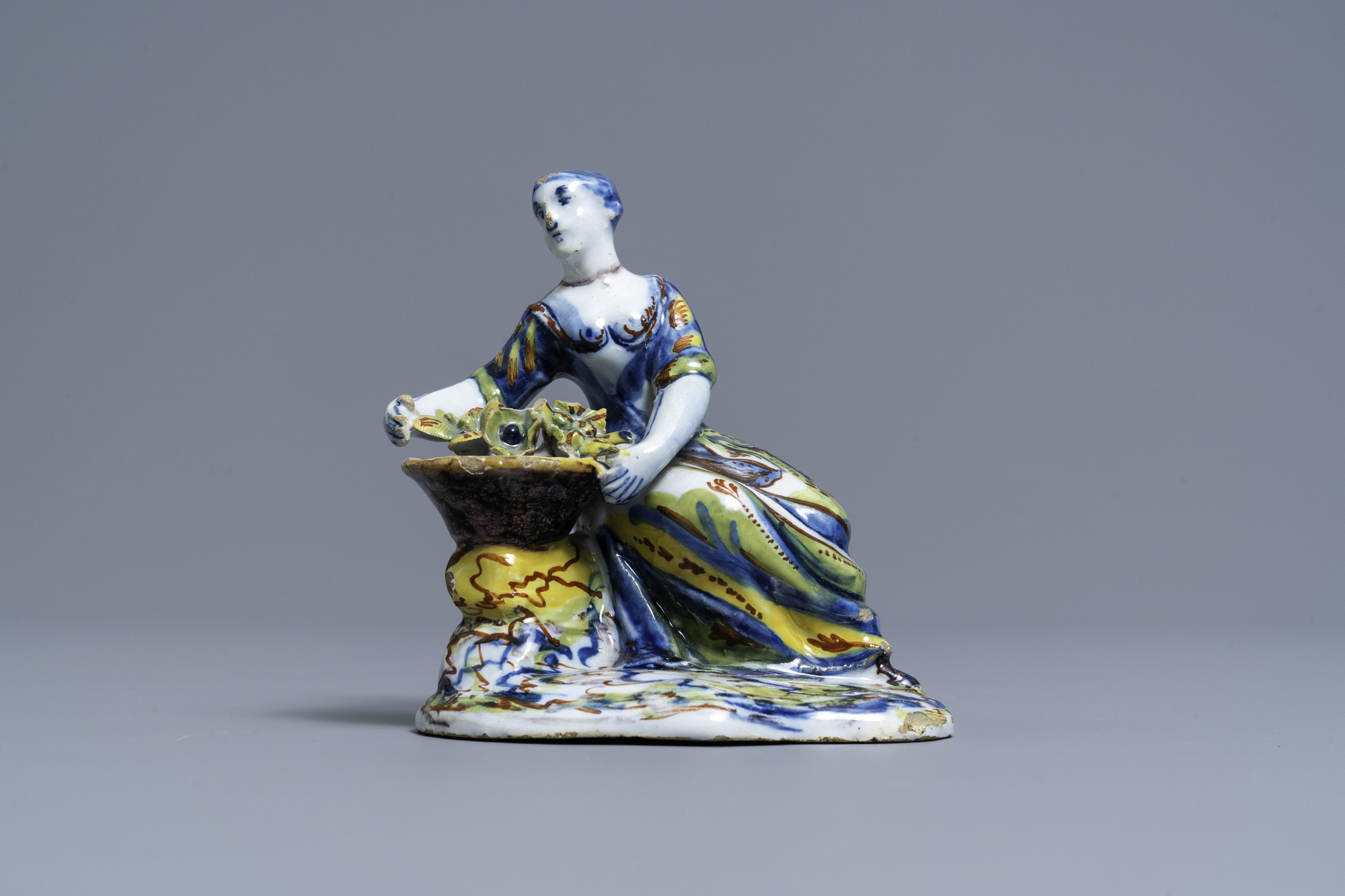 A polychrome Dutch Delft figure of a lady selling flowers, 18th C. - Image 2 of 6