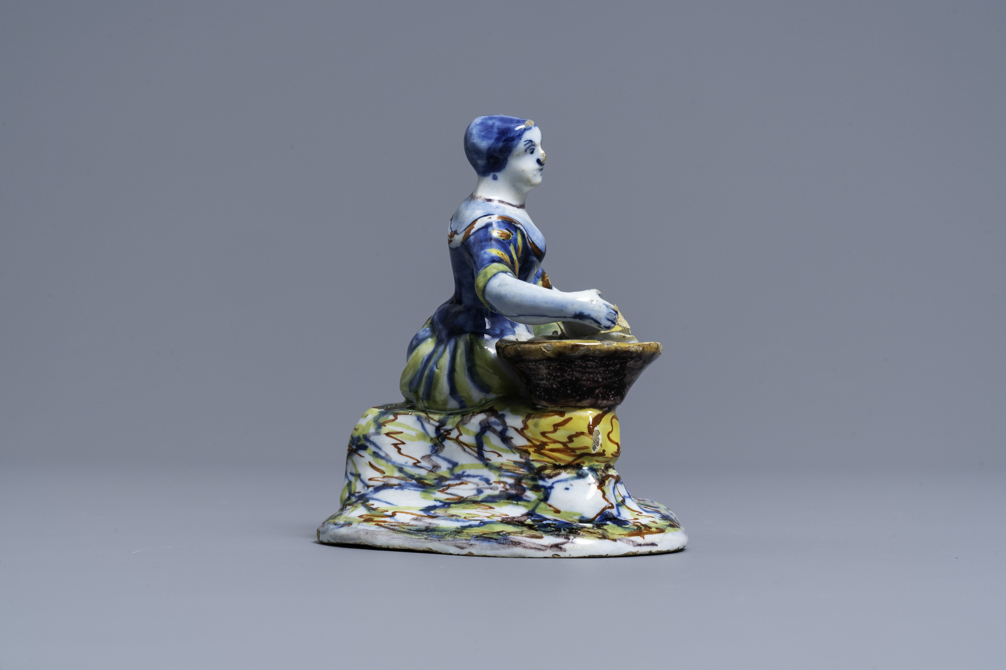 A polychrome Dutch Delft figure of a lady selling flowers, 18th C. - Image 3 of 6