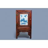 A Chinese hongmu cupboard with a blue and white 'Buddhist lions' plaque, 19th C.