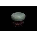 A Chinese pale celadon jade 'phoenix and peony' circular box and cover, 19th C.