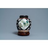 A Chinese black-ground famille rose jar, 19th C.