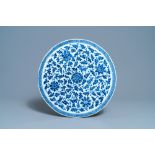 A large Chinese round blue and white plaque with floral design, 19th C.