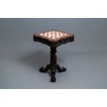 A Chinese carved wooden side table with marble chessboard top, 19th C.