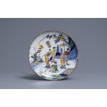 A polychrome Dutch Delft chinoiserie plate with figures in a garden, 18th C.