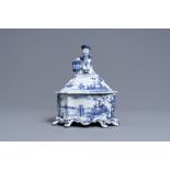 A Dutch Delft blue and white tobacco box and cover with a boy near a barrel, 18th C.