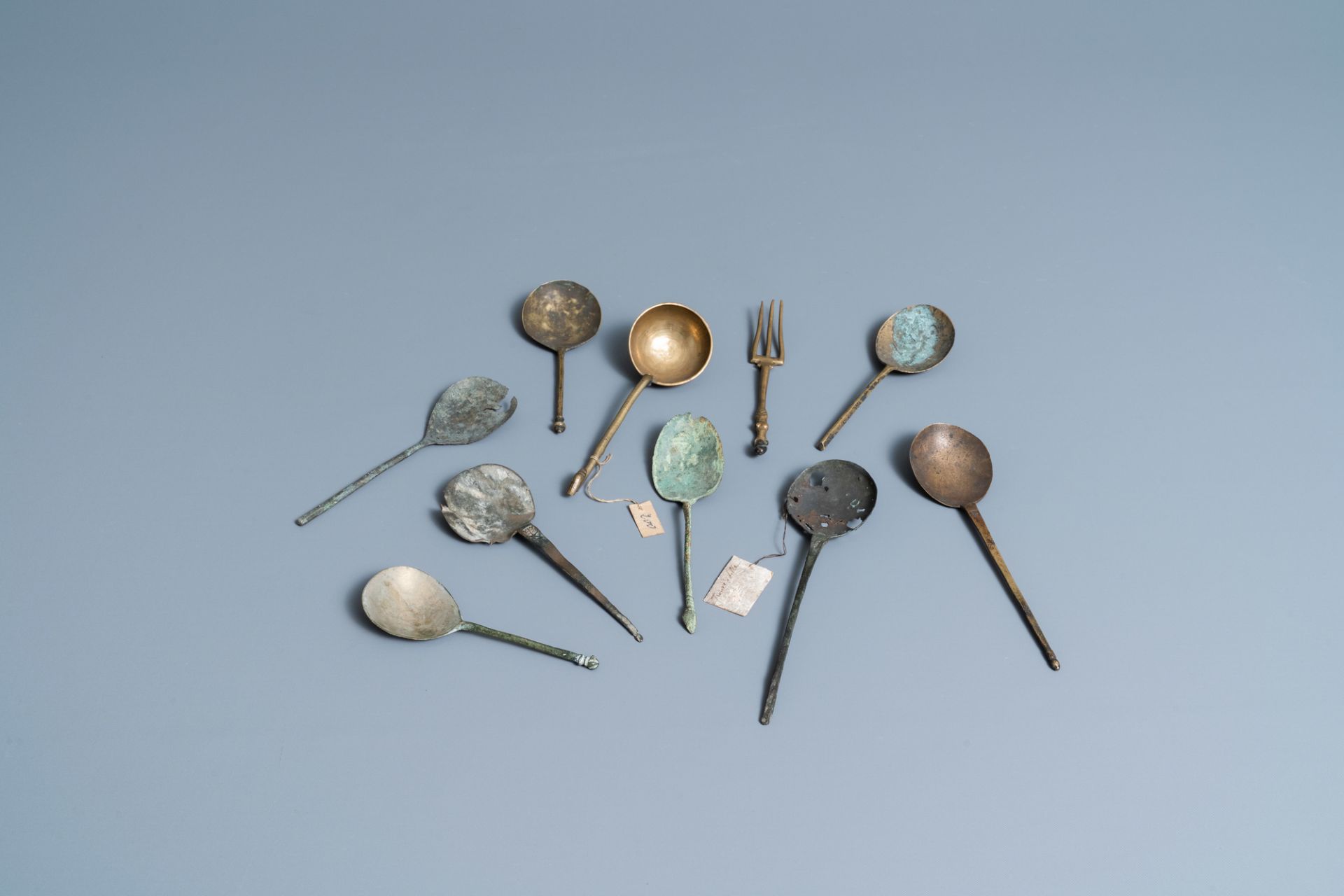 Nine brass spoons and a small fork, 15/16th C.