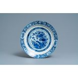 A Dutch Delft blue and white dish with a peacock in a Chinese garden, dated 1693