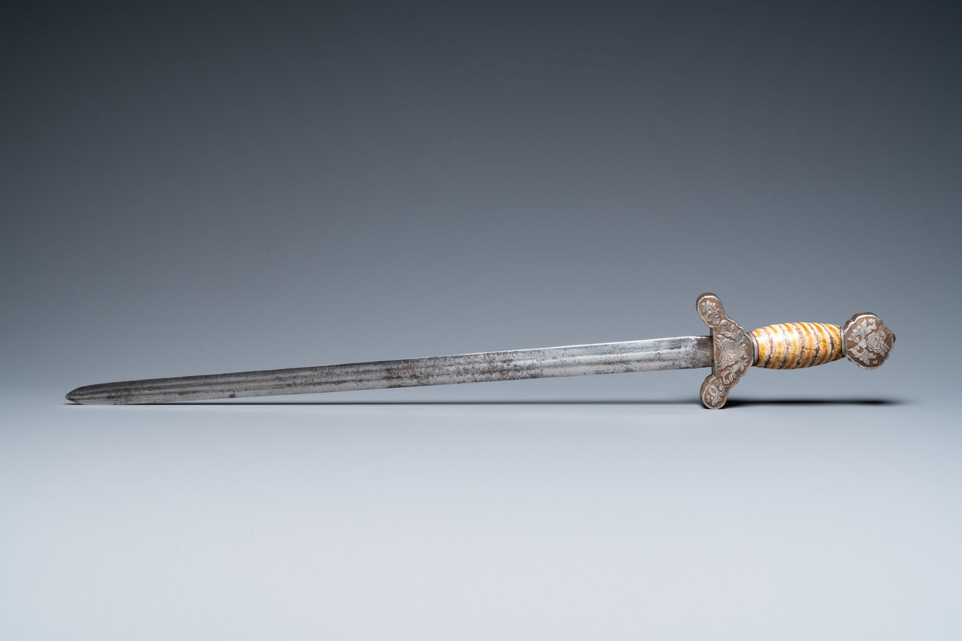 A Tibetan steel sword with silvered copper and mammoth tooth hilt, 19th C. - Image 2 of 7