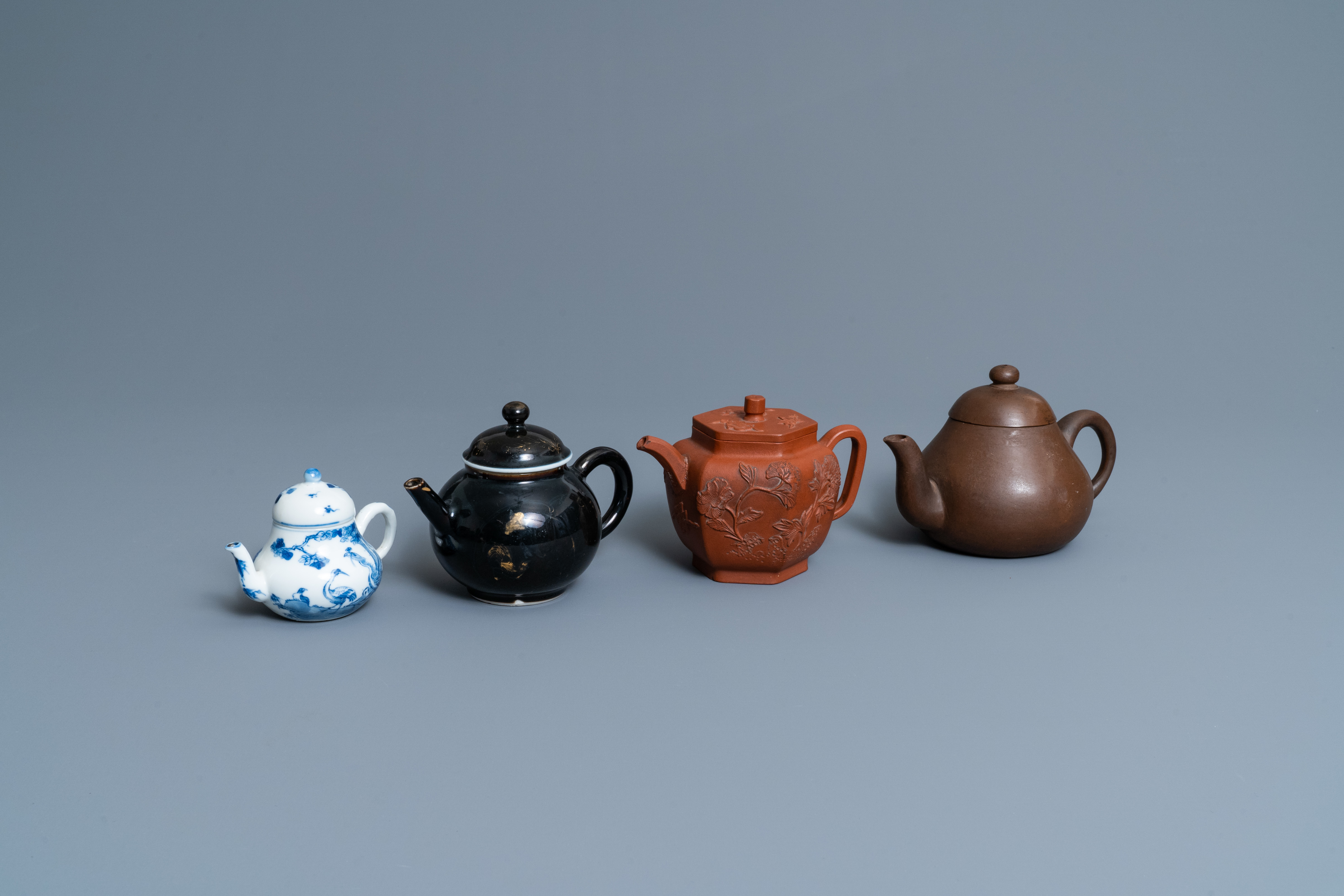 Four Chinese Yixing stoneware, blue and white and monochrome black porcelain teapots, Kangxi and lat
