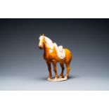 A Chinese amber- and cream-glazed pottery model of a horse, Tang